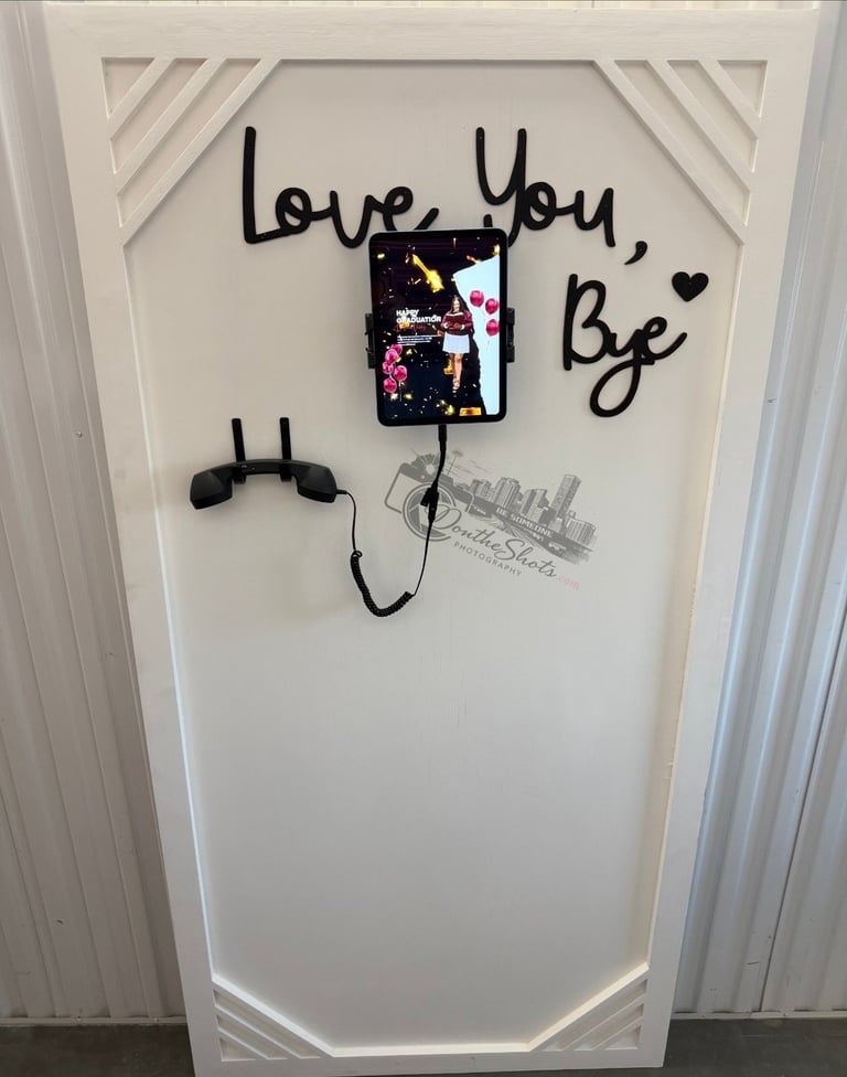 Wall art with love you, bye text in black marker, decorative photo clip, and headphones on white board