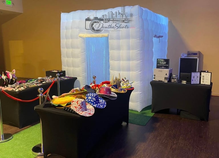 Trade show booth with inflatable photo backdrop, black tables displaying products, and signage for CloudlineShots photography service